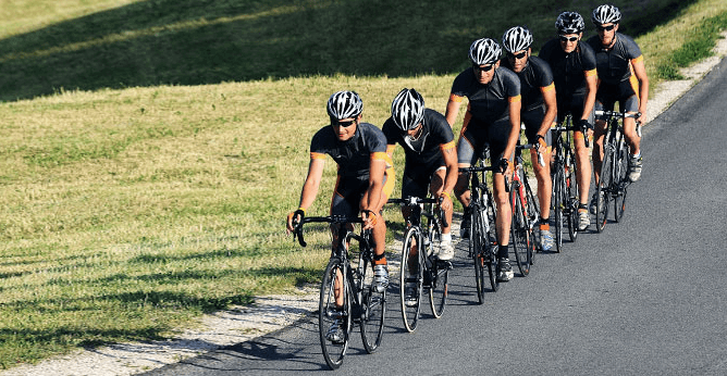 How should riders communicate with each other during group rides?